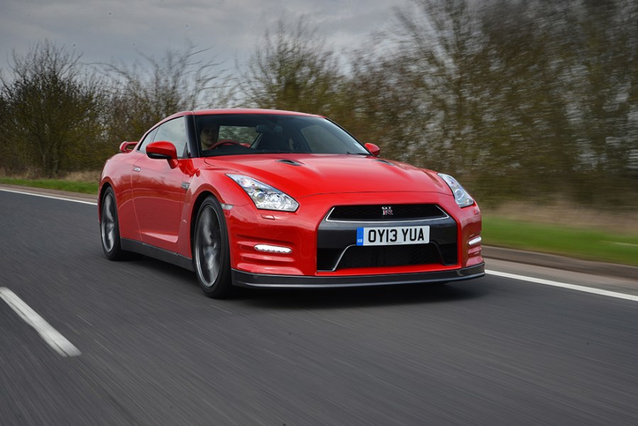 A front right shot of a red Nissan GT R R35 driving