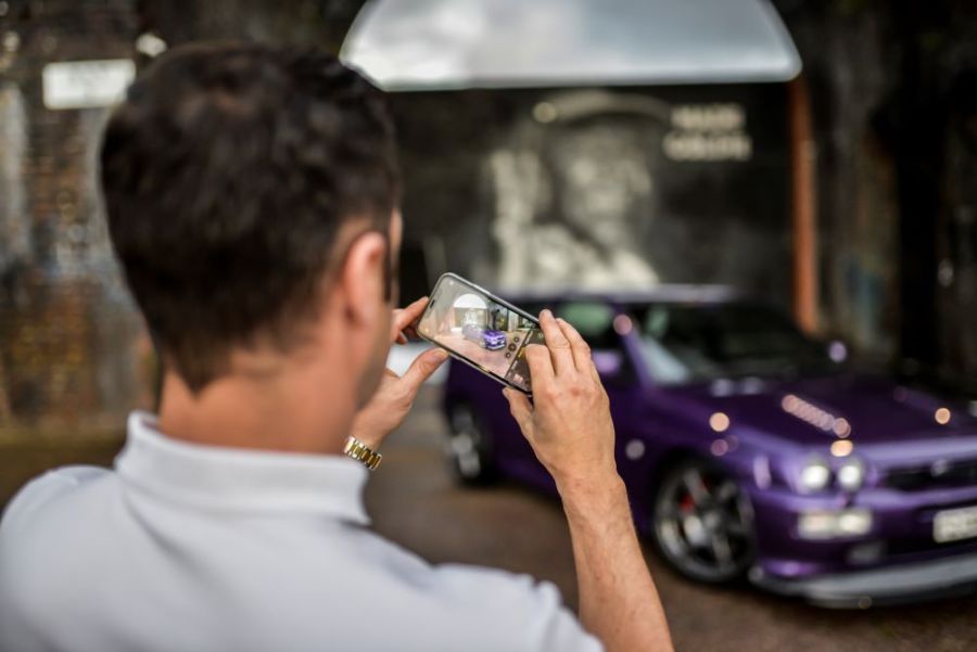 man taking photo of car