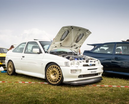 Car at a show with nice wheels celarly visible