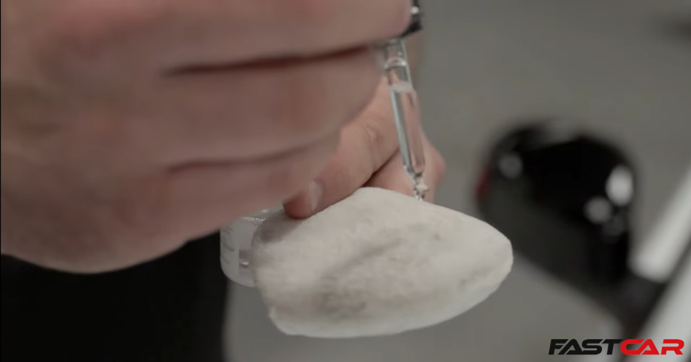 man applying drops of ceramic coating to an applicator pad 