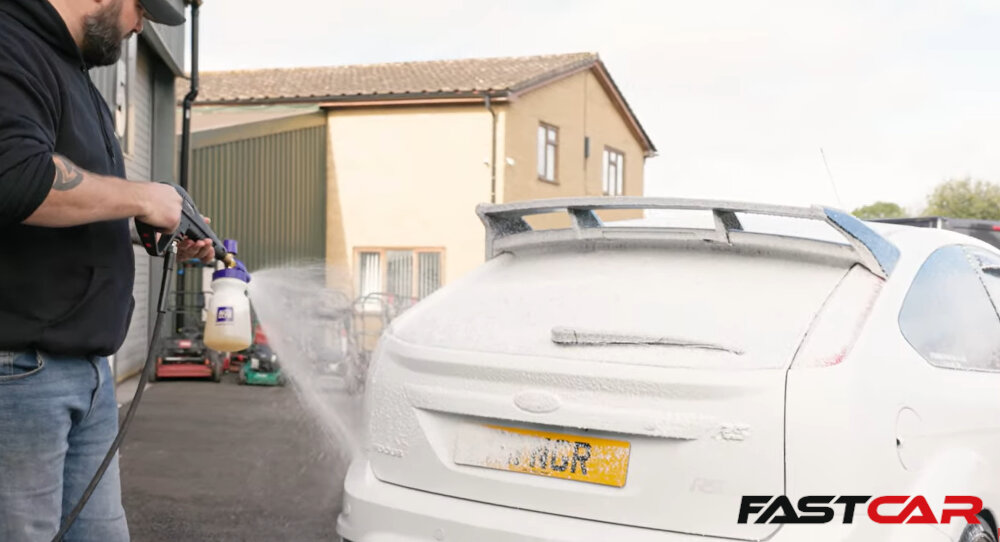 Man applying snow foam to a car